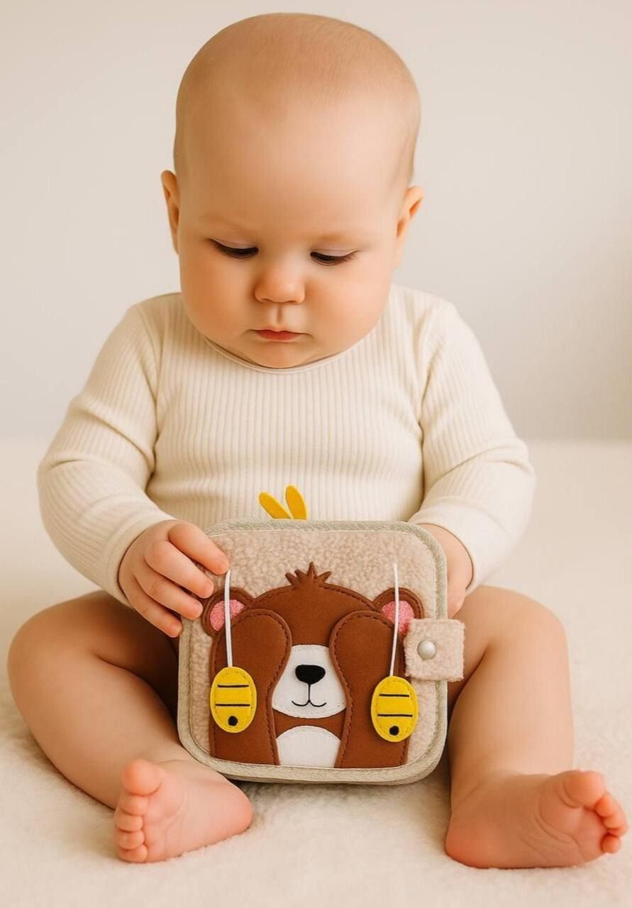 Bébé de 6 mois manipule le livre sensoriel Montessori Janazur